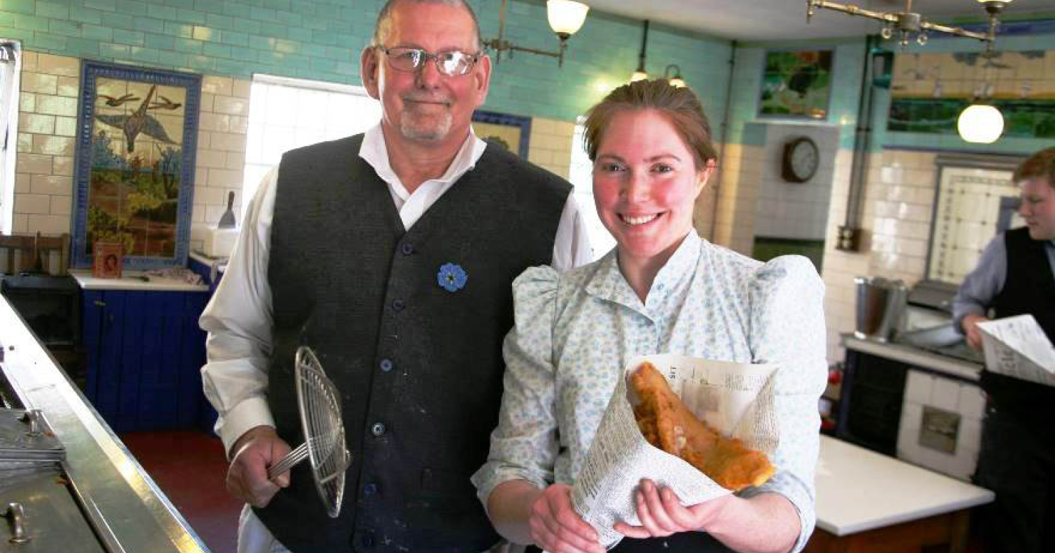costumed staff holding fish and chips at Davy's fish shop at Beamish Museum